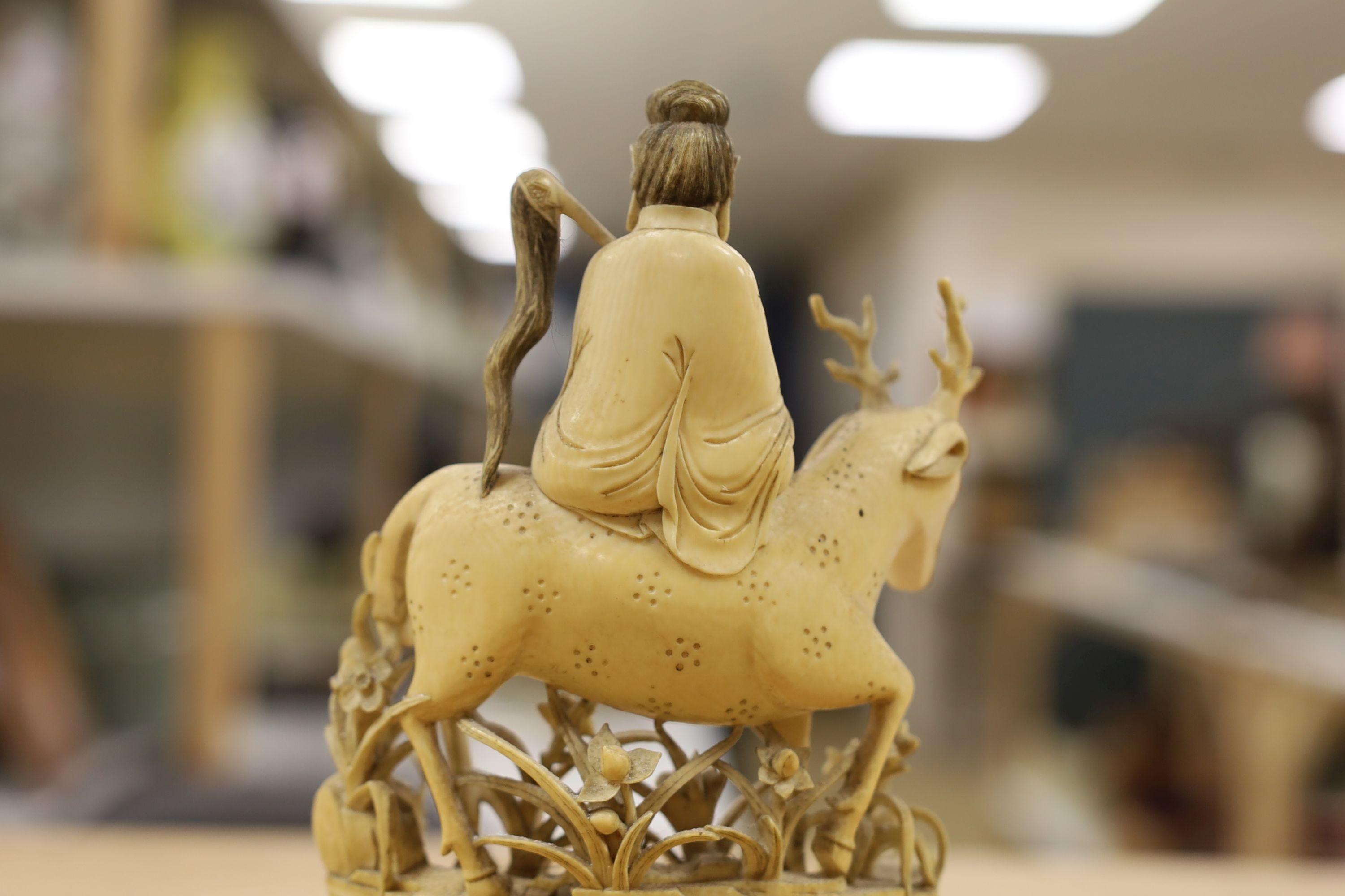 A Chinese carved ivory figure of a female immortal riding a deer, early 20th century, height 17cm excl. stand